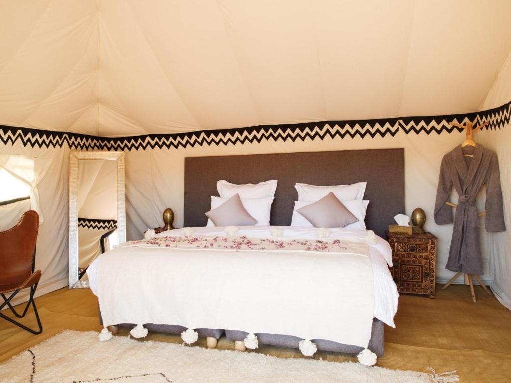 interior of a tent with a double bed at the nubia luxury camp erg chegaga