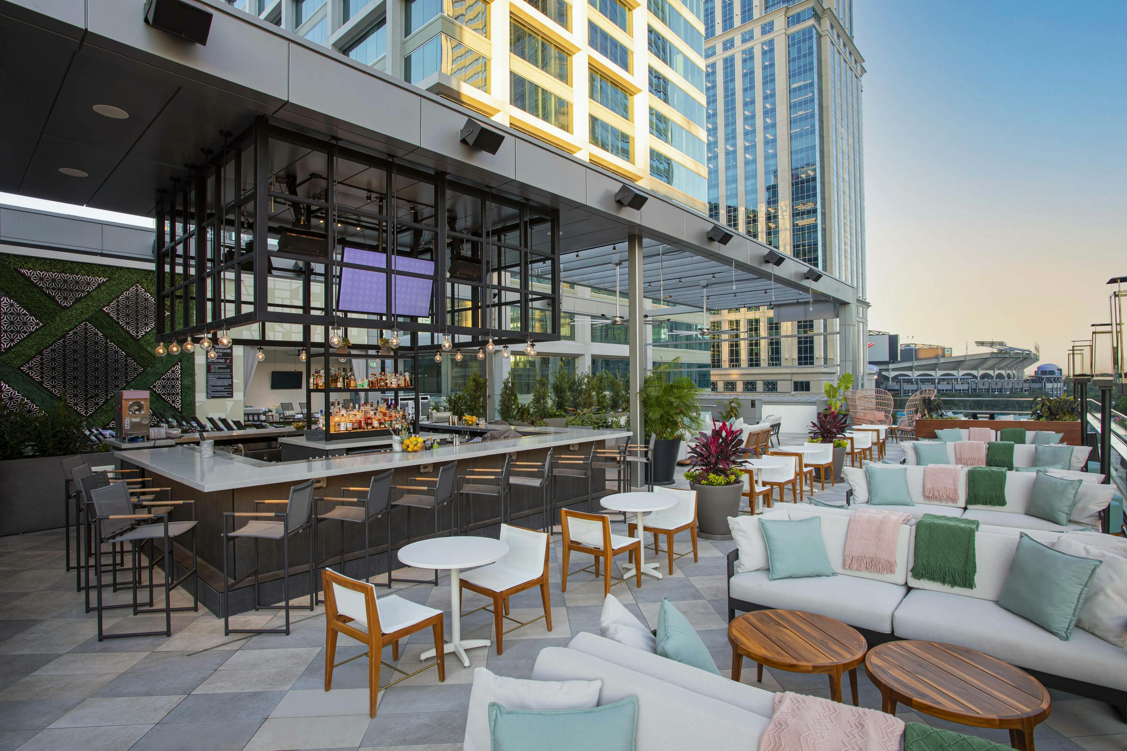 Rooftop bar with couches and tables and the bar itself in the middle